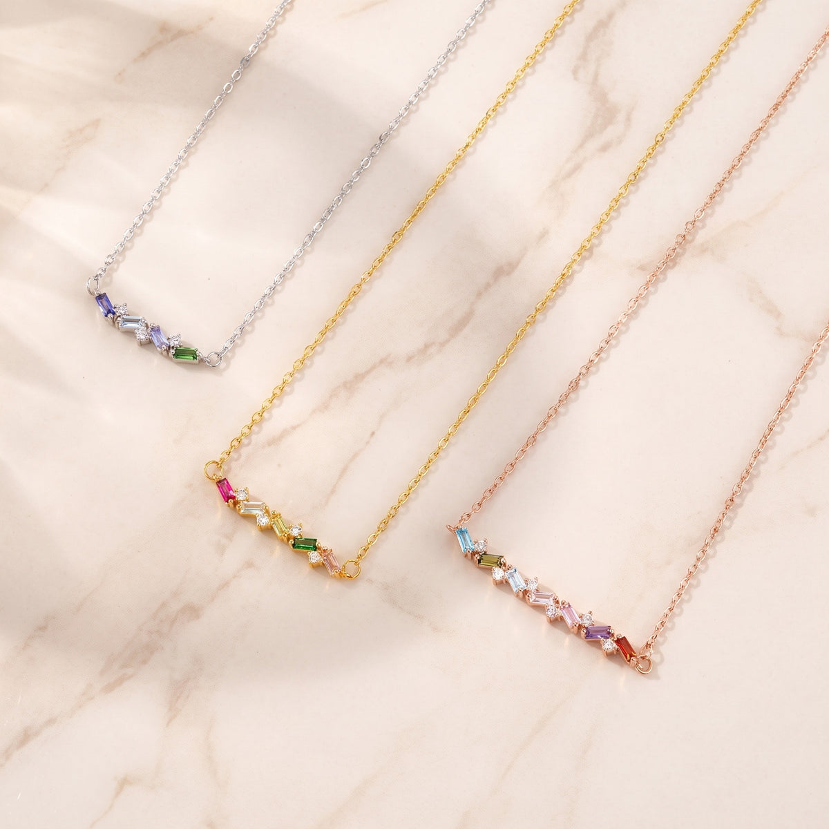 Personalized Baguette Birthstones Necklace, flat lay in silver, gold and rose gold
