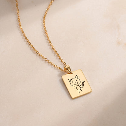 Gold kids drawing necklace engraved with a child's cat drawing