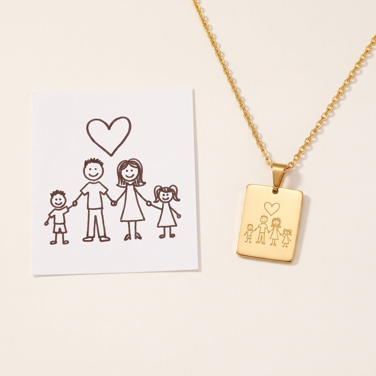 A child's drawing on paper next to the pendant engraved with the same drawing