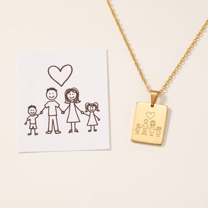 A child's drawing on paper next to the pendant engraved with the same drawing