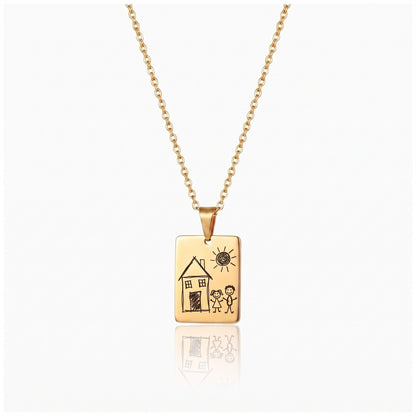Gold kids drawing necklace engraved with a toddler drawing of a house, the sun and two stick figures
