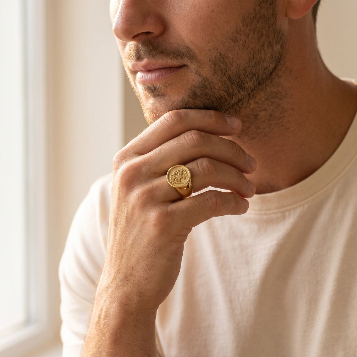 Family signet ring on a man's hand at his jaw