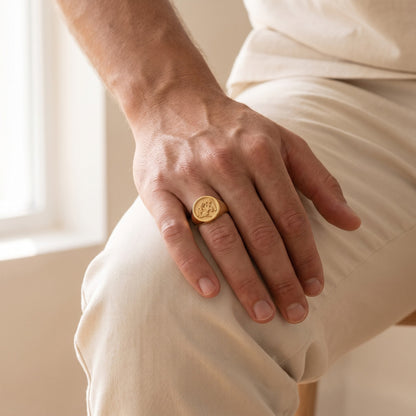 Family crest signet ring on a man's hand resting on his knee
